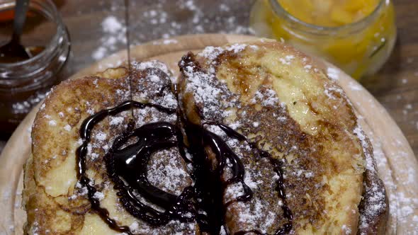 Pouring topping on tasty French toasts