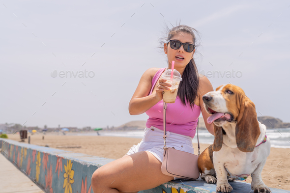 Woman and beagle dog enjoying a day on the beach