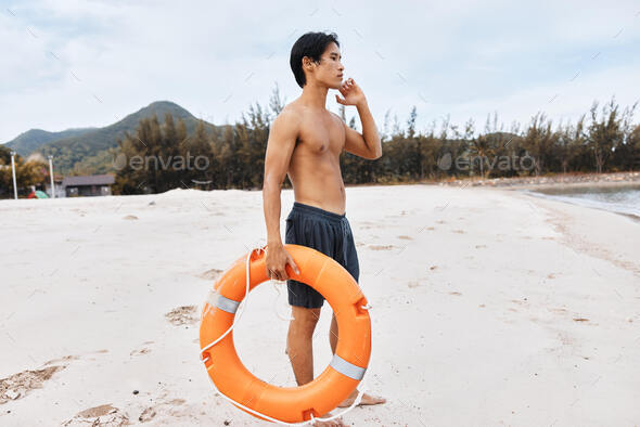 Lifeguard on the Beach, Summer Asian Man Saving Lives - A depiction of a diligent lifeguard in