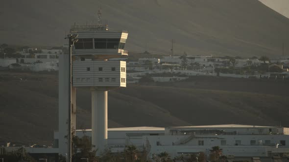 An observation tower in the rays of evening sun against the mountain slopes alt