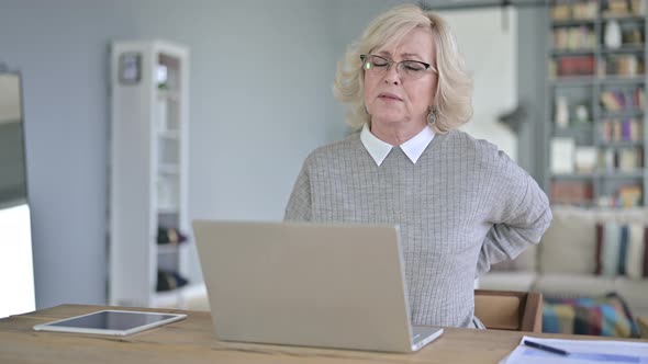 Tired Old Woman Having Back Pain in Modern Office alt