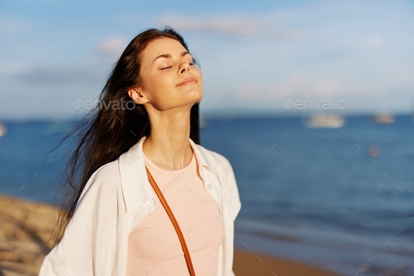 Woman beauty smile with teeth freedom on vacation walks along the beach ...