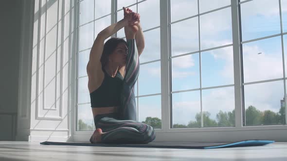 Young Female Doing Yoga in a White Room Filled with Light the Girl Performs Yoga Stands Near the alt