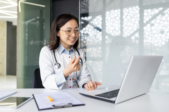 Asian female doctor providing remote consultation in modern clinic office environment