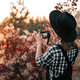 Young pretty woman takes pictures with DSLR camera outdoors on autumn background - PhotoDune Item for Sale