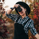 Young pretty woman takes pictures with DSLR camera outdoors on autumn background - PhotoDune Item for Sale
