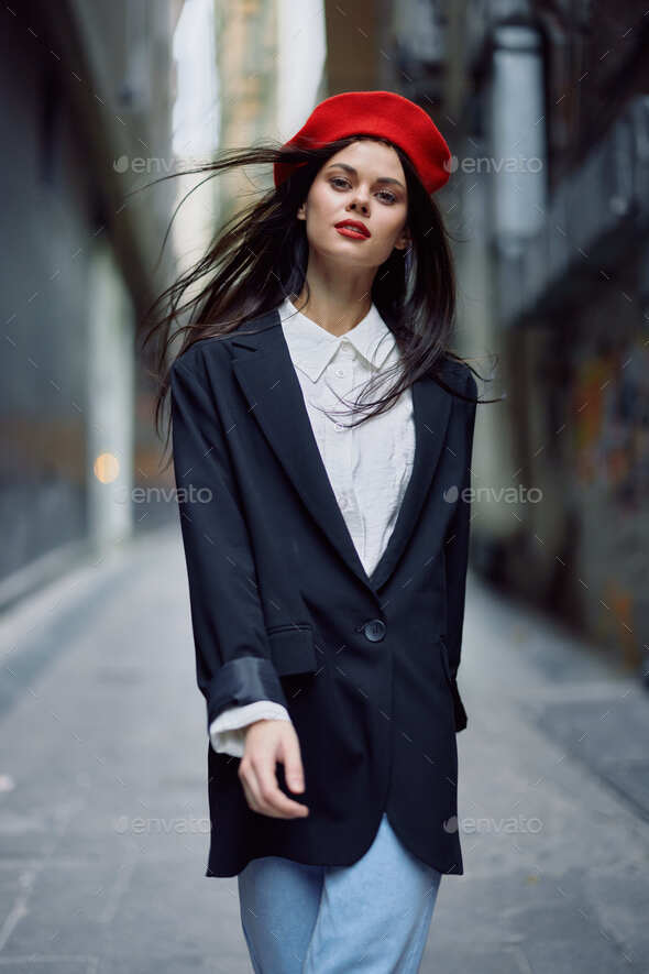 Fashion woman portrait walking tourist in stylish clothes with red lips  walking down narrow city Stock Photo by shotprime