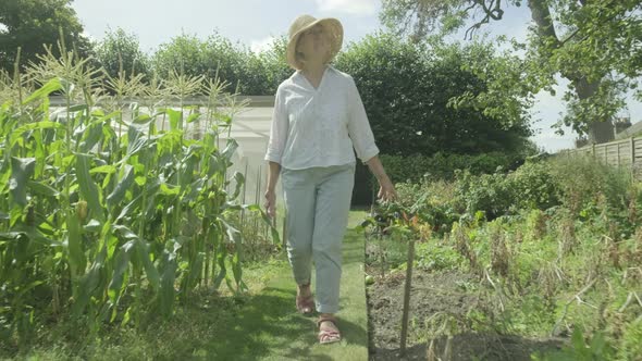 Senior caucasian woman walking through her garden
