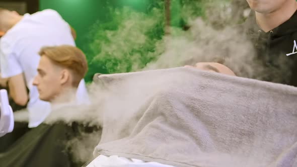 Barber Covers Client with Towel Sitting Against Humidifier alt