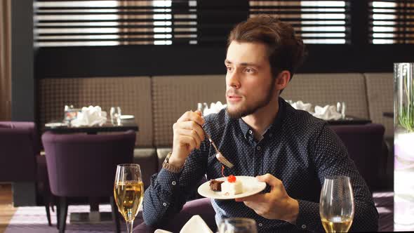 Elegant Pensive Guy Sitting and Eating Yummy Cake alt