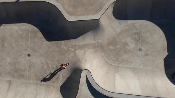 Anonymous person riding skateboard in skate park alt