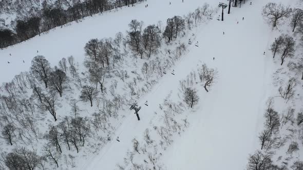 chair lift taking skiers on the snow mountain in winter at ski resort in nozawa onsen japan alt