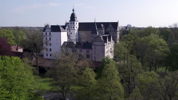 Low rotating shot of Wolfsburg castle with trees in front alt