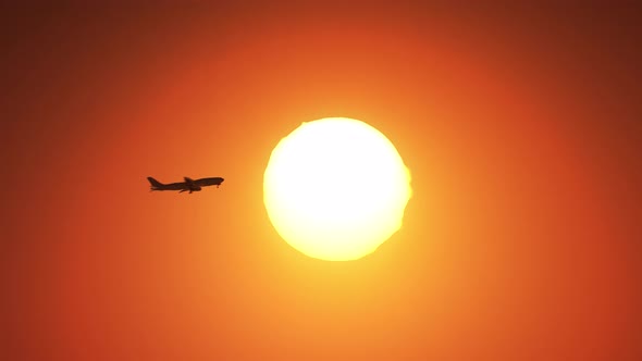 Airplane flying in the air with full sun in background.