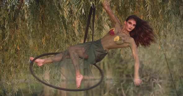 Young Pretty Woman with Body Art and Makeup is Spinning in a Hoop alt