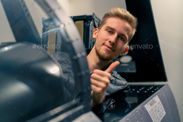 guy sitting in flight simulator of military plane after virtual flight shows hand sign super fun
