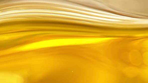Super Slow Motion Shot of Moving Oil Waves on Golden Background at 1000Fps alt
