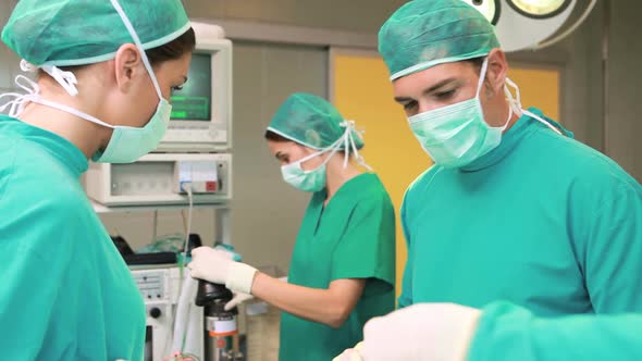 Surgeon and a nurse next to a patient alt