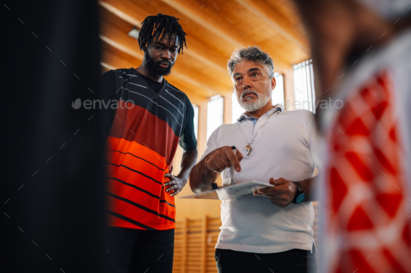 Basketball coach explaining game tactics to his interracial team.