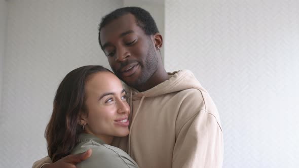 Portrait Of Loving Young Couple At Home Hugging In Kitchen Together alt