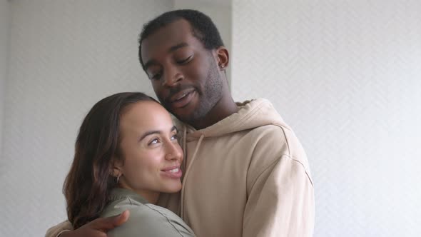 Portrait Of Loving Young Couple At Home Hugging In Kitchen Together