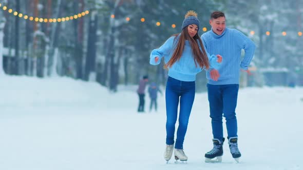 Man Dances with Girlfriend on Outdoor Skating Rink