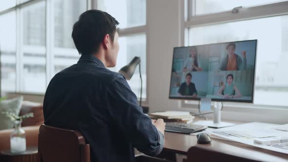 Back rear view smart millennial asian male employee using computer monitor