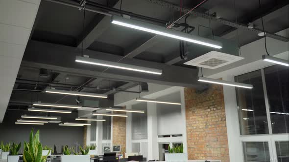 Turning on light in empty office with pc and monitors 4K. Shot with movement alt