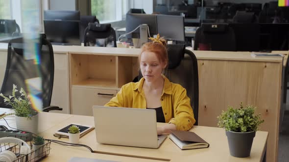 Red-Haired Woman Working In Office alt