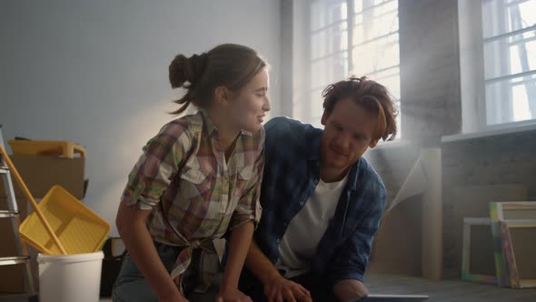 Happy Family Enjoying Draft of House Renovation on Floor alt