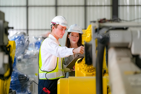 Indusrtial Robot technology, Engineers inspecting stock of welding robots at factory. - Stock Photo - Images