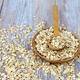 Oat flakes uncooked in wooden bowl with spoon on rustic table. Concept of healthy eating - PhotoDune Item for Sale