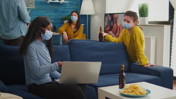 Happy African Woman Showing Video on Laptop to Friend alt