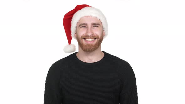Portrait of Attractive Man 30s with Shaved Head Smiling and Wearing Santa Claus Red Hat Isolated alt