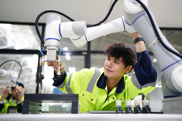 Robotic Arm engineer check on equipment in its with software of Artificial Intelligence Unit. - Stock Photo - Images