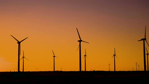 Wind Turbines in Action Generating Eco Energy at Sunset. alt