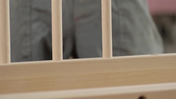 A Wooden Peg is Inserted Into the Hole of the Side Protection of the Crib