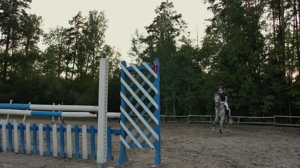Young Female Rider on Bay Horse Jumping Over Hurdle on Equestrian Sport Competition alt