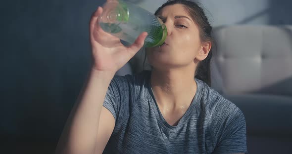 Lady in Grey Tshirt Drinks Water After Intensive Training