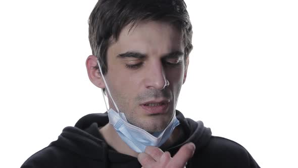 A Portrait of a Young Man in a Medical Mask Sprays Spray in His Mouth with Sore Throat, Isolate