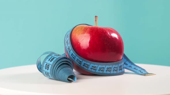 A Side View of Blue Measuring Tape and Fresh Fruits on a Whiteboard