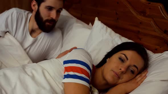 Couple arguing on bed in bedroom alt