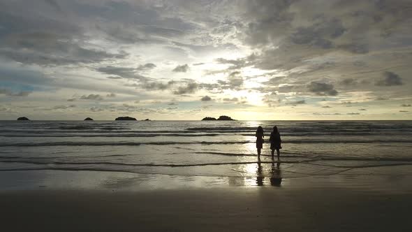 Aerial view of two womans taking photos of the sunset, Ko Chang, Thailand. alt