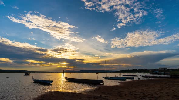 day to night time lapse of wooden boat at banks of the river with sunset alt
