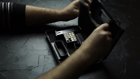 Preparing Pistol for Shooting on a Black Texture Table
