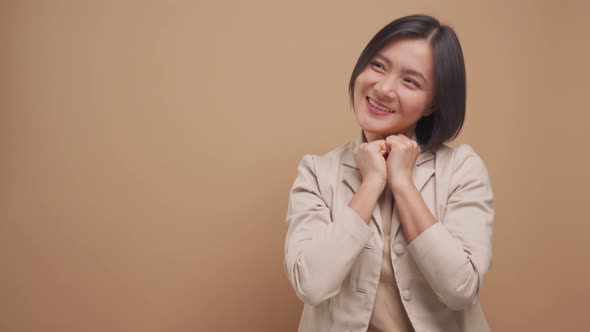 Confident asian business woman happy and make winning gesture with copy space isolated