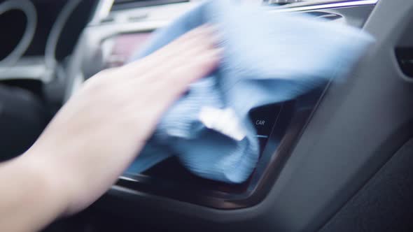 A Man Wipes the Car Radio Display with a Cloth - Closeup alt