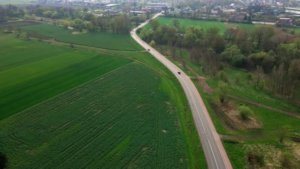 Car Driving on Road Among Agricultural Fields alt