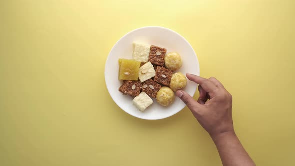 Top View of Hand Pick Indian Sweet in a Bowl on Table alt