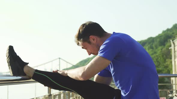 Handsome Athletic Man Stretching His Legs Before Morning Outdoor Workout alt